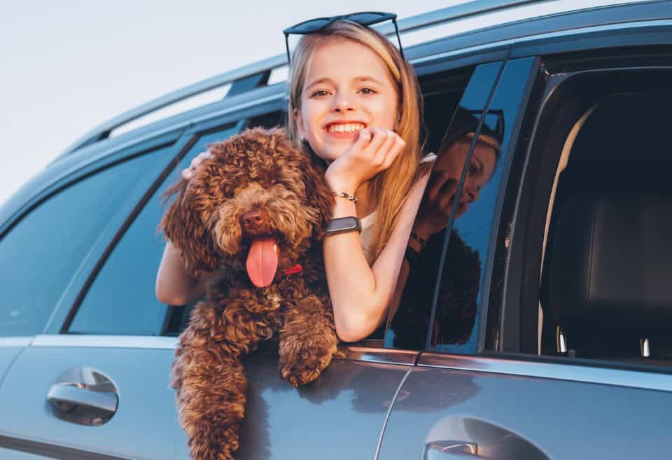 Girl with dog Hanging out the window