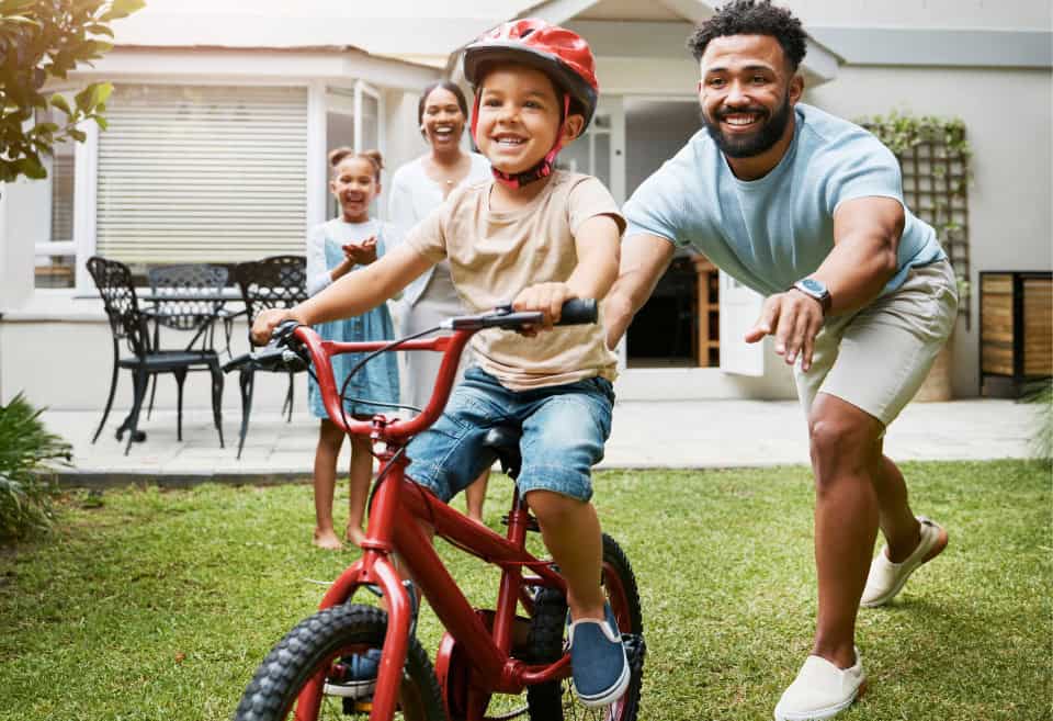 Dad teaches son to ride a bike
