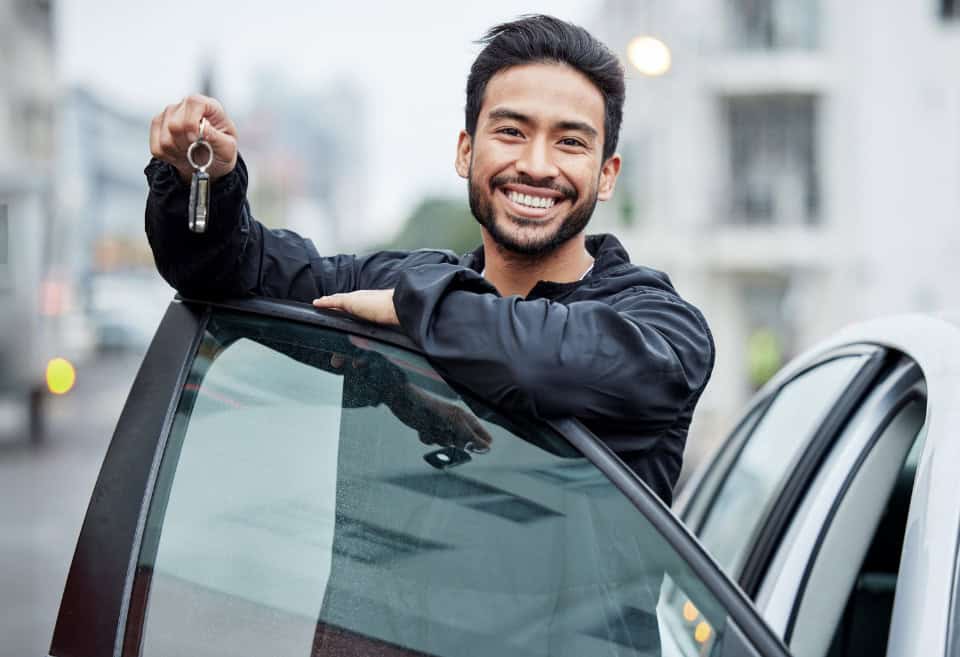 Male showing off the keys of his new car