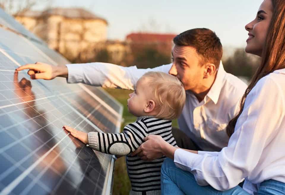 Family and son looking at a solar panel