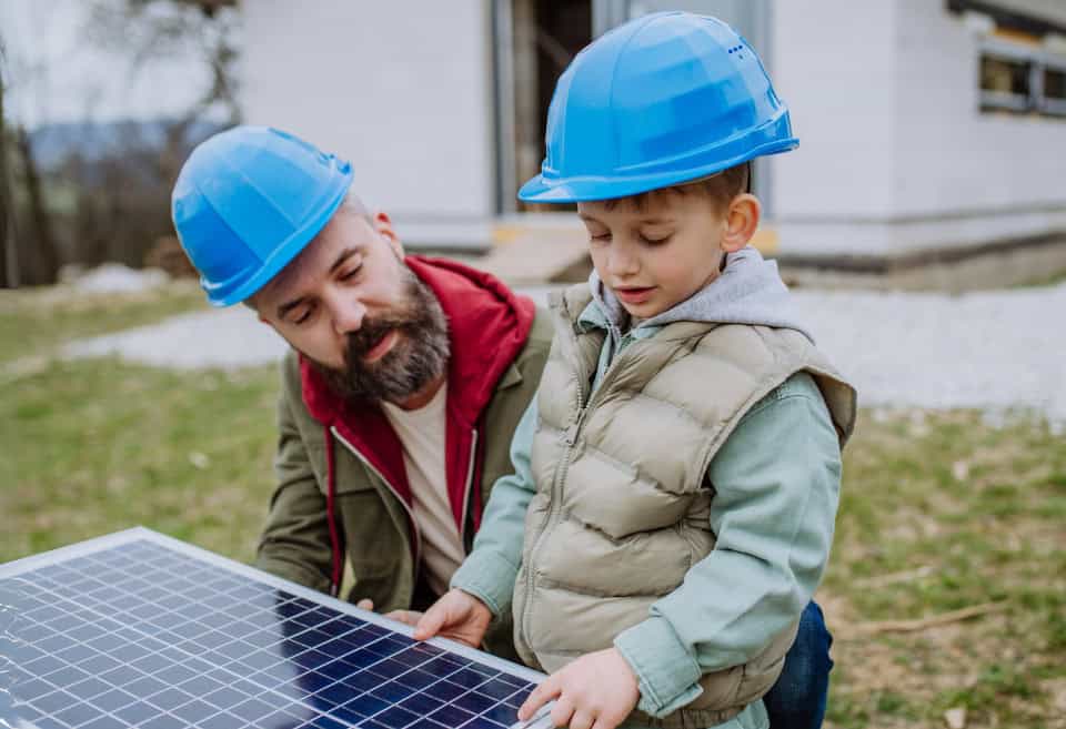 Father and son looking at a solar panel