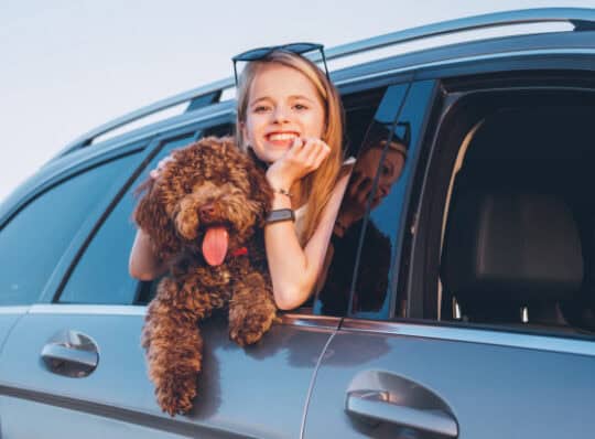 Girl with dog Hanging out the window
