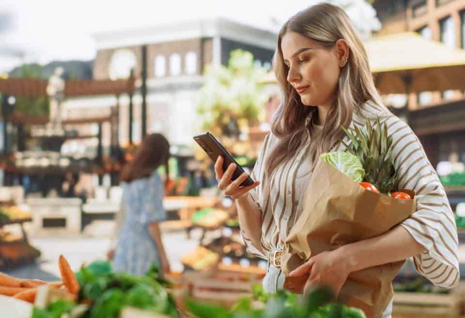 woman paying with zelle at a farmers market