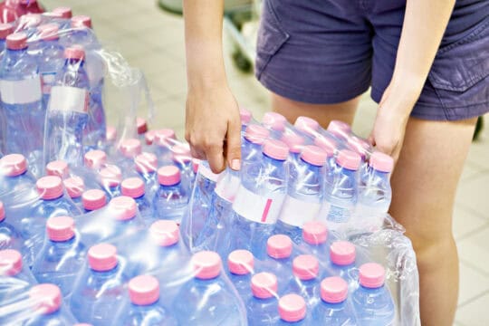 Person picking up water bottle donations