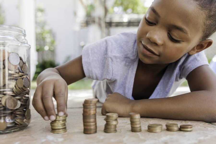 A child counting coins and learning how to save money.